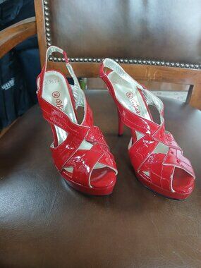 Vibrant strapped red patent leather pumps. New and unworn.